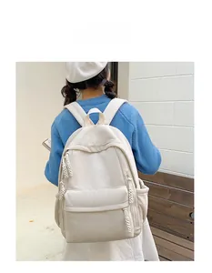 Detailansicht des cremefarbenen Cord-Rucksacks mit Reißverschlusstasche und Seitenfach