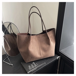Close-up of matte brown suede tote bag texture with vertical stitching on display