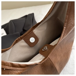 Détail du sac cabas marron montrant le fermoir magnétique argenté et la texture du cuir