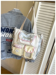 Detail of college-style crossbody bucket bag with multi-color pockets and nylon texture