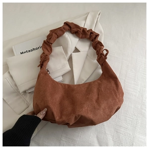 Détail du sac croissant marron caramel avec texture en daim et poignée plissée souple