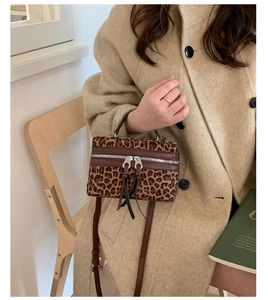 Détail d'un sac boîte léopard avec double fermeture éclair et longues pompons
