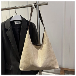 Macro detail of large suede tote bag featuring contrasting leather shoulder straps