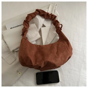Détail du sac croissant en daim marron avec bandoulière froncée et taille smartphone