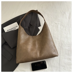 Gros plan du grand sac cabas vintage marron avec texture cuir et coutures verticales