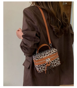 Sac boîte chic à motif léopard avec bordure en cuir porté sur un blazer marron