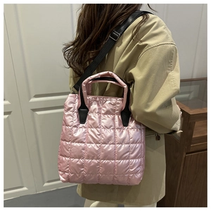 Detail of pink quilted bucket bag showing metallic texture and adjustable nylon strap