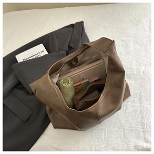 Vue intérieure du sac hobo vintage marron avec parapluie, carnet et pochette