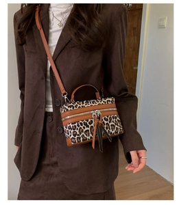 Détail du sac boîte léopard avec garniture en cuir marron et bandoulière réglable
