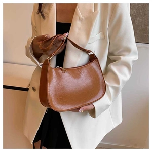 Detail of a brown oil-wax leather crescent shoulder bag showing zipper and texture