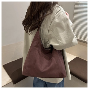 Detail of dark brown suede tote bag showing soft texture and slouchy minimalist design