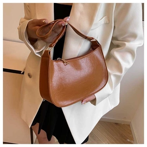 Detail view of caramel faux leather shoulder bag with crocodile texture and gold zipper