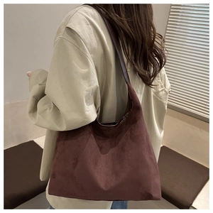 Detail of dark red suede hobo bag showing texture and oversized silhouette on model