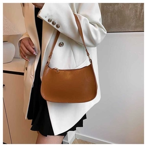 Brown hobo underarm bag with gold zipper shown on a model in a white blazer jacket