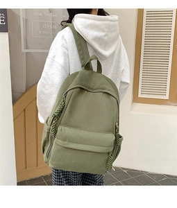 Grasgrüner Cord-Rucksack mit großem Fassungsvermögen und Seitentasche am Modell