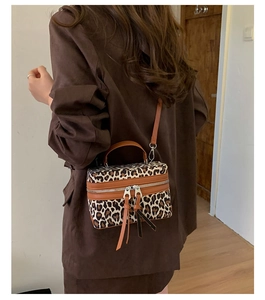Vue détaillée du sac boîte léopard avec deux longs glands en cuir et une poignée haute