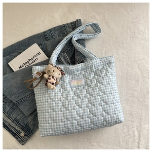 Detail of blue heart quilted tote bag with leopard doll charm and denim accessories