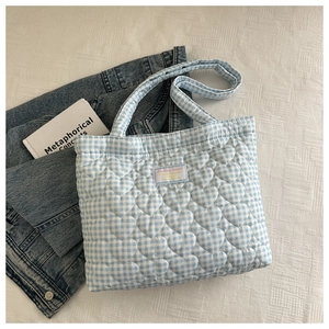 Close-up of heart-shaped quilting on a blue and white checkered quilted tote bag