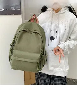 Detailsicht des grasgrünen Cord-Rucksacks mit gewebten Reißverschlusszügen am Modell