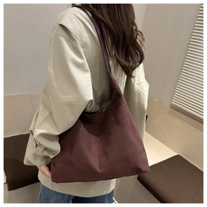 Detail of burgundy suede hobo bag showing the rich matte texture and wide shoulder strap
