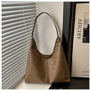 Détail du sac hobo marron montrant la texture du cuir PU mat et sa grande capacité