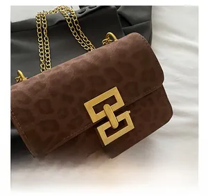 Detailed close-up of premium leopard print suede crossbody bag with gold geometric buckle