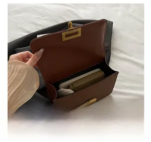 Internal view of brown leather crossbody bag showing capacity for phone and cosmetics