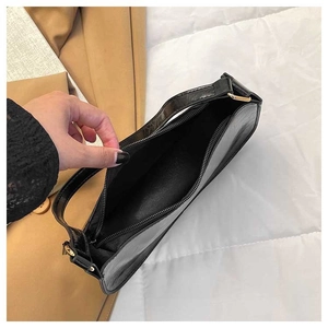 Detail view of the spacious black minimalist underarm bag interior with zipper closure