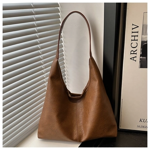 Détail de la texture d'un grand sac cabas vintage en similicuir souple marron élégant