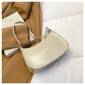 Detail of cream white underarm bag showing wrinkled oil wax texture and gold zipper