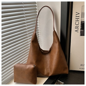 Détail du sac hobo marron foncé et de sa pochette assortie en cuir texturé vintage