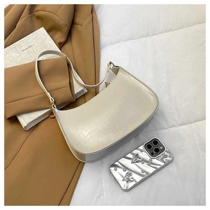 Detail of a creamy white half-moon hobo bag with a glossy leather texture and stylish strap