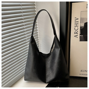Vue artistique d'un grand sac fourre-tout noir vintage texturé sur un rebord de fenêtre