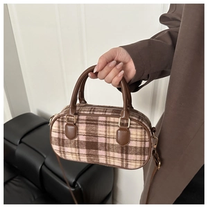 Detail of vintage plaid Boston bag showing leather handles and textured wool fabric