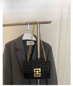 Detail of leopard print bag with gold chain strap and metallic square lock closure