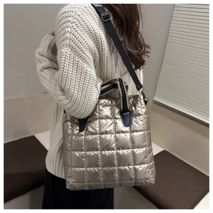 Détail du sac cabas matelassé or champagne avec poignées noires et éclat métal