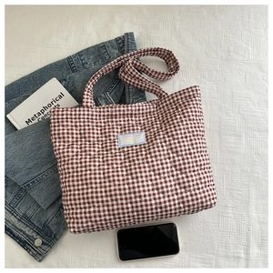 Close-up of heart-shaped quilting and brown plaid texture on a cotton tote bag