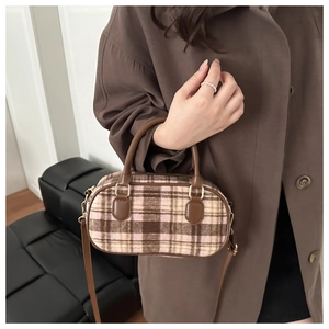 Detail of wool plaid Boston bag with leather handles and gold-tone hardware