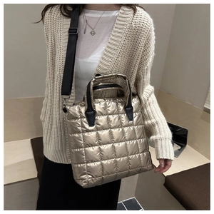 Champagne gold quilted tote bag with black handles and wide nylon shoulder strap