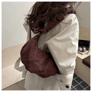 Détail du sac hobo marron foncé avec plis de cordon et bandoulière à nœuds décoratifs