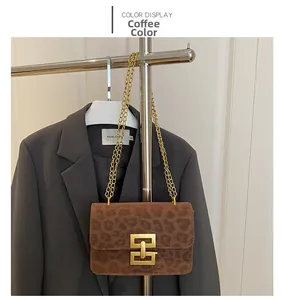 Detail of leopard print crossbody bag with vintage gold lock and metal chain strap