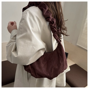 Gros plan d'un sac nuage en daim bordeaux vintage avec bandoulière à plis froncés