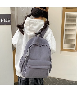 Detail eines grauen Cord-Rucksacks mit Rippstruktur und gewebten Seil-Reißverschlüssen
