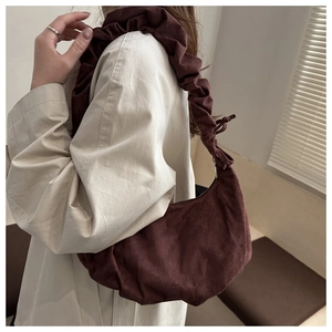 Détail du sac hobo en velours côtelé marron foncé avec bandoulière réglable froncée