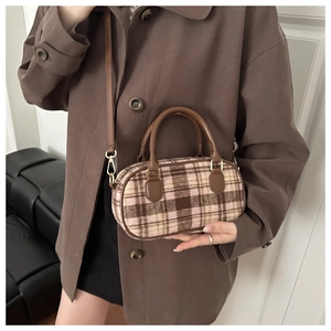Close-up of a vintage plaid woolen Boston bag for kids paired with a brown winter coat
