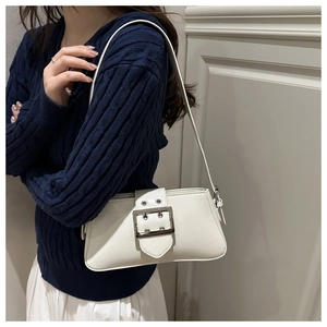 Detail of cream PU leather underarm bag featuring silver buckle and wide strap