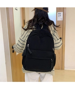 Detaillierte Rückansicht eines schwarzen Cord-Rucksacks mit weicher Textur und Größe