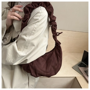 Détail du sac hobo en velours côtelé marron foncé avec bandoulière à volants plissés