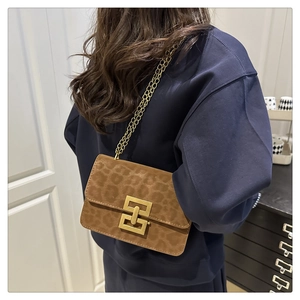 Close-up of leopard print crossbody bag with gold chain strap and metal clasp detail