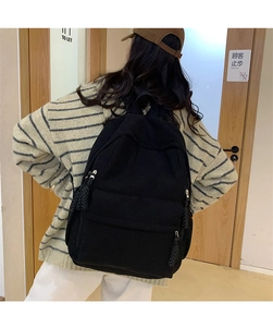 Detaillierte Rückansicht eines schwarzen Cord-Rucksacks mit gewebten Reißverschlusszügen